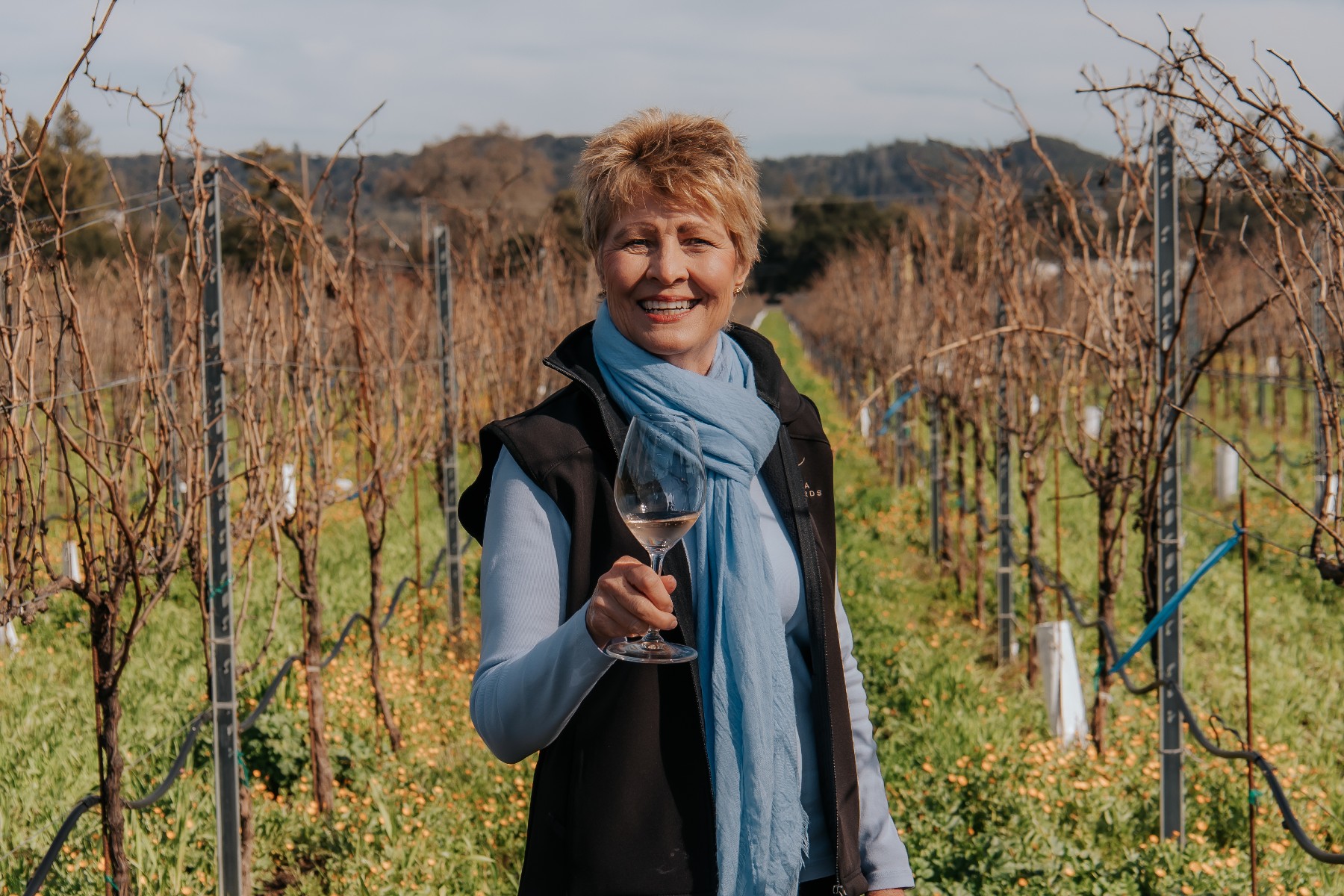 Amista Proprietor Vicky Farrow with Glass of Sparkling Wine in Vineyard