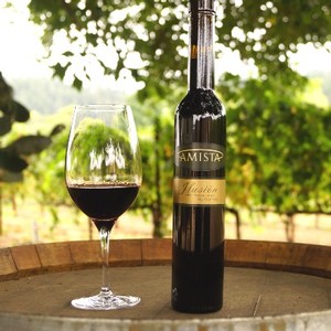Amista Vineyards Ilusion Dessert Wine Glass & Bottle on Barrel in Vineyard