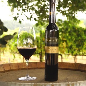 Amista Vineyards Ilusion Dessert Wine Glass & Bottle on Barrel in Vineyard
