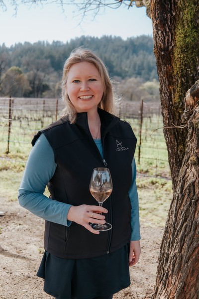 Amista Vineyards Hospitality and Outreach Manager Holding Glass of Sparkling Grenache