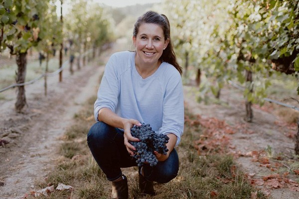 Amista Vineyards Winemaker Ashley holding Grenache grapes in the vineyard